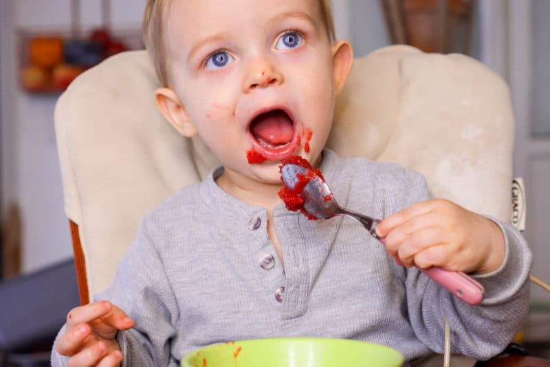 toddler eating cranberry applesauce