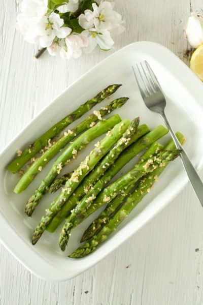 shallow white dish with lemon garlic asparagus