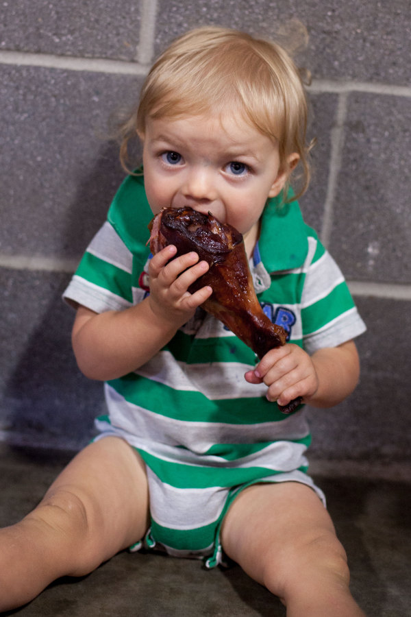 1 year old eating turkey leg at the Puyallup Fair. EatingRichly.com