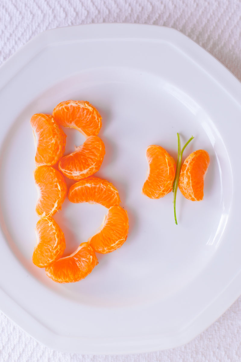 This cute healthy kid snack uses tangerines to teach preschoolers the alphabet. B is for butterfly! Get more alphabet kid snack recipes at EatingRichly.com