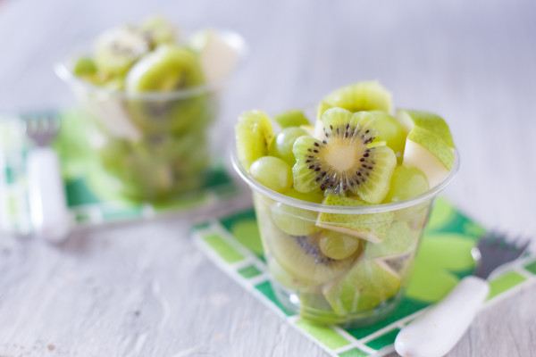 This simple fruit salad uses green kiwi, pear, and grapes. Perfect for a cute St. Patrick's Day kid snack! - EatingRichly.com