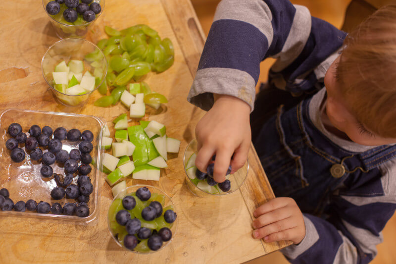 This fruit salad is a healthy football appetizer that's perfect for Seahawks fans. Green apples and grapes are layered with blueberries in individual servings for a football snack that is so easy to make, a toddler can do it! Part of #MiniChefMondays on EatingRichly.com