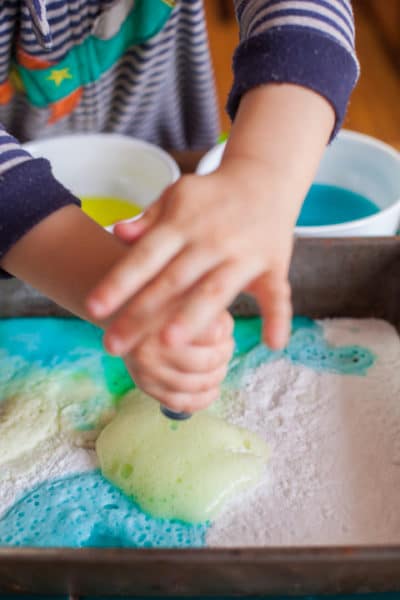 This toddler science experiment teaches how baking soda and vinegar react, while making a colorful art project. You toddler won't believe their eyes! Part of #MiniChefMondays on EatingRichly.com