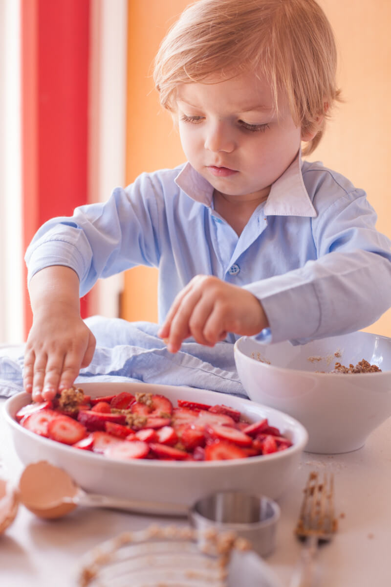 Three year old kid chef getting ready to bake an easy strawberry cobbler for dessert. From EatingRichly.com