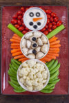 This Christmas Veggie Tray Snowman is easy enough for kids to make, and too cute to resist. It's the perfect simple appetizer for holiday parties! From EatingRichly.com