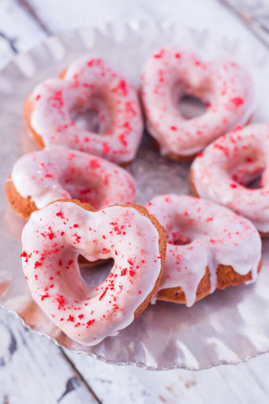 These strawberry sprinkle donut hearts are made with crumbled freeze dried strawberries, and a sweet lemon glaze, for a gorgeous dye free strawberry lemonade treat perfect for Valentine's Day. From EatingRichly.com