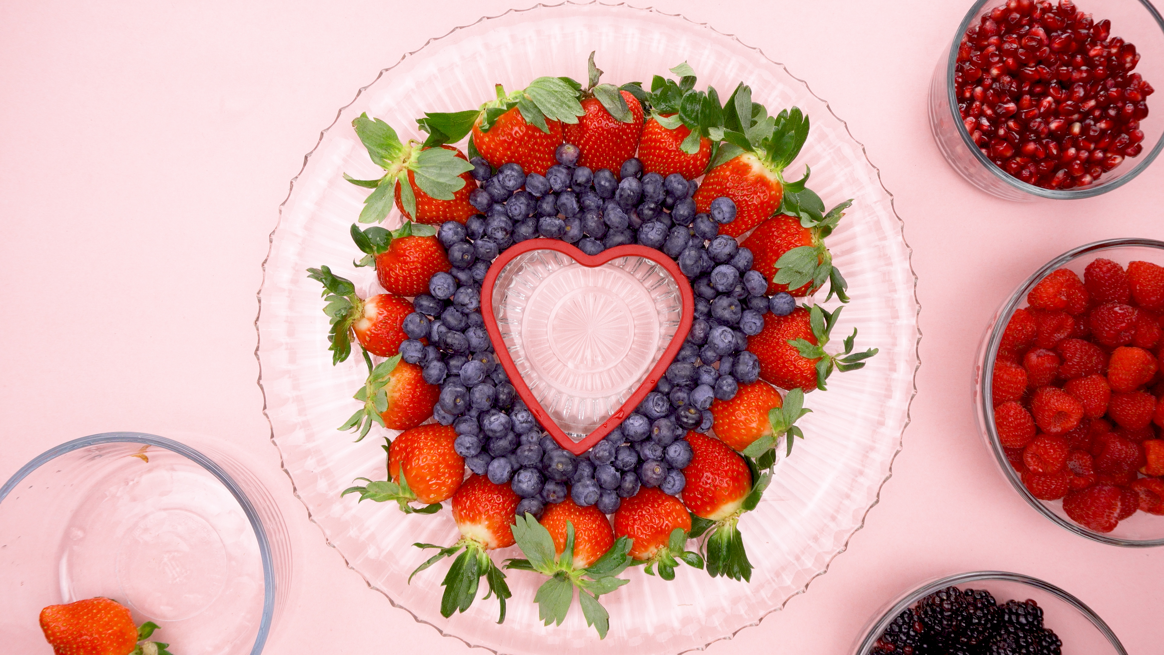 Strawberries and blueberries around a heart cookie cutter