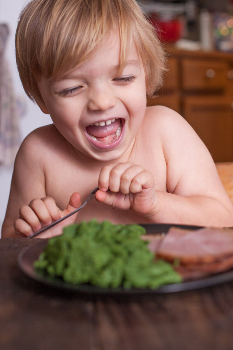 Child laughing at green eggs and ham