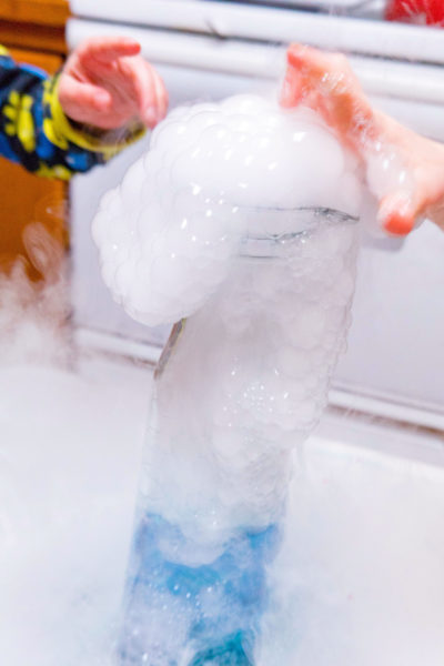 Kids touching dry ice bubbles