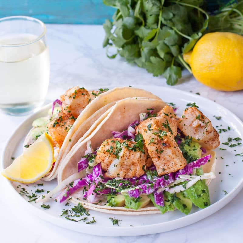 Plate of fish tacos with slaw and avocado