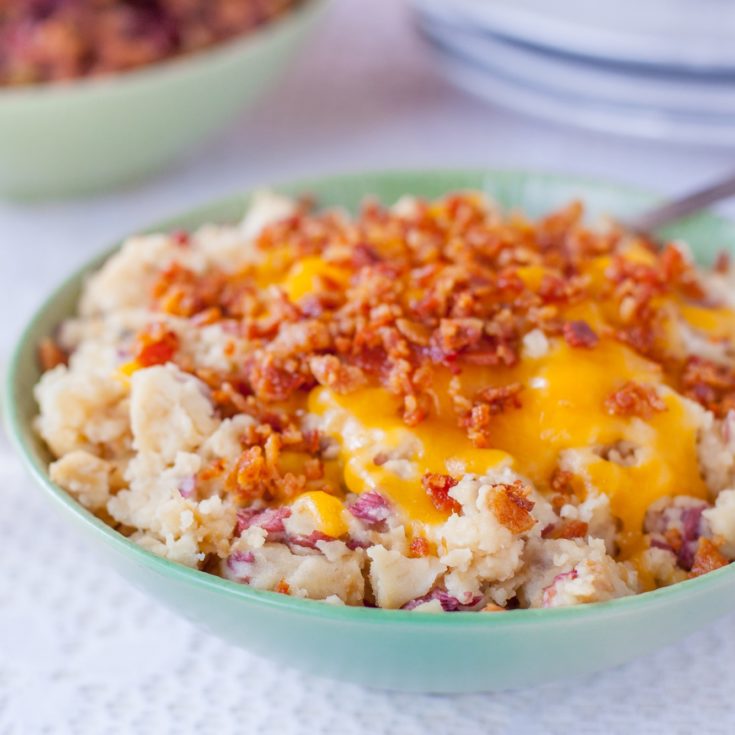 Bowl of cheesy bacon topped red skin mashed potatoes