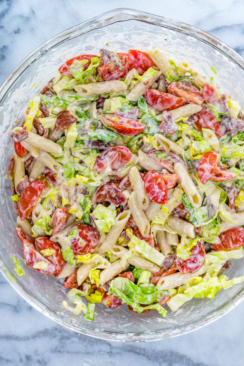 Overhead of large glass mixing bowl full of BLT pasta salad
