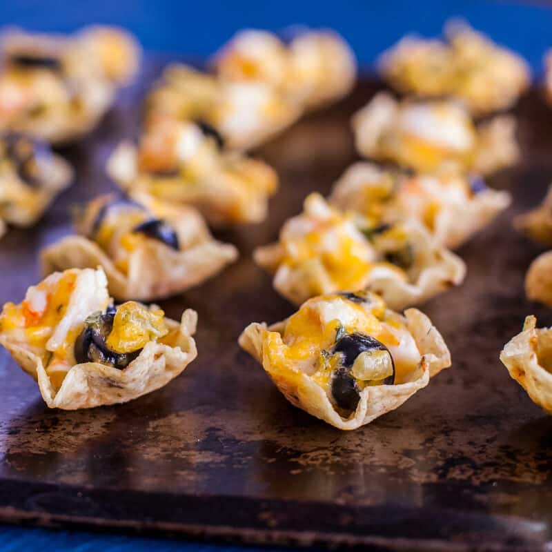Schoop chips stuffed with cheesy shrimp filling on a baking sheet with a deep blue background