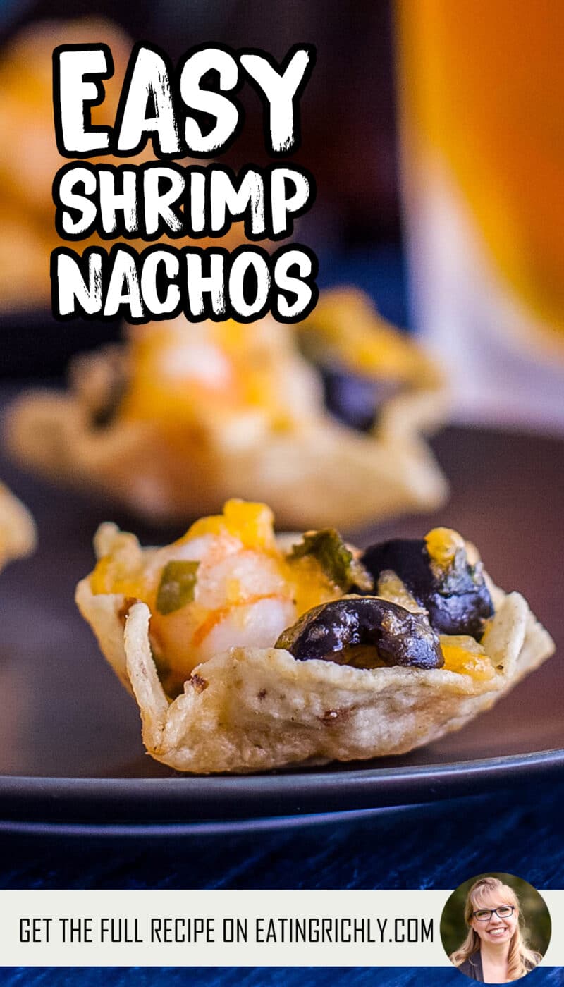 Close up of a shrimp, cheese, and olive filled tortilla scoop with another shrimp nacho and a beer in the background. Text reads Easy shrimp nachos.
